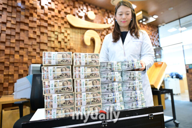서울 명동 하나은행 위변조대응센터에서 직원이 달러화를 옮기는 모습./마이데일리