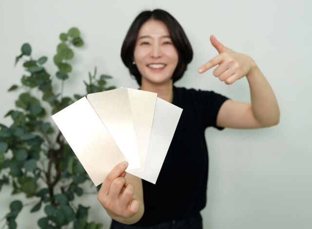 KCC 관계자가 실제 금속(왼쪽에서 두 번째)과 숲으로메탈릭을 칠한 종이를 비교하고 있다. /KCC
