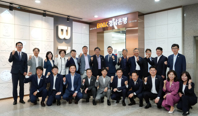 경남은행 최진권 상무와 김해지역 영업점장들 그리고 김해시 홍태용 시장과 공무원들이 확장 이전한 경남은행 김해시청지점 앞에서 단체 기념촬영을 하고 있다./경남은행