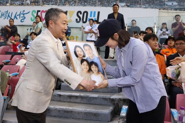 2018년 순직한 故심문규 소방장 유가족에게 AI 복원 가족사진, 쌍둥이 자녀에게 선물 전달하고 있는 박정원 구단주./두산 베어스
