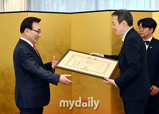 24일 서울 성북구 일본대사관저에서 미즈시마 고이치 일본대사(오른쪽)가 김기병 롯데관광개발 회장에게 '욱일중수장'을 수여하고 있다. 사진=송일섭 기자