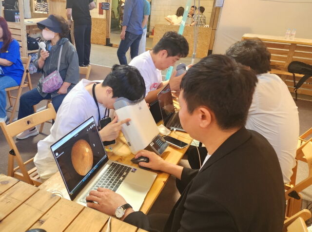 대웅제약 부스 방문객이 위스키와 옵티나를 활용해 안저 상태를 확인하고 있다. /대웅제약