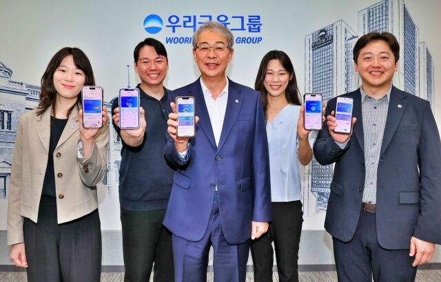 우리금융그룹 임종룡 회장(가운데)이 지난 6일 유니버설뱅킹 신규 가입자 100만명 돌파를 기념해 직원들과 사진 촬영을 하고 있다. /우리금융그룹