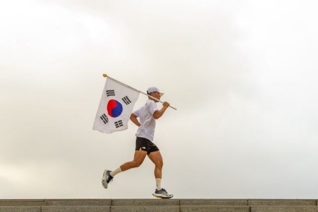 가수 션이 태극기를 들고 마라톤을 하고 있다./ YG엔터테인먼트