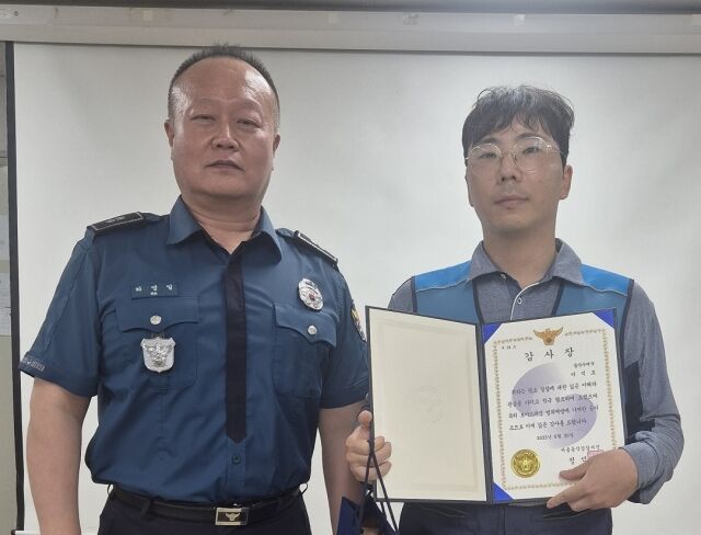 이석호 서울동작우체국 집배원(오른쪽)이 19일 보이스피싱 범죄예방 기여 공로로 하영일 서울남성지구대장에게 감사장을 받고 기념 촬영을 하고 있다. /서울지방우정청