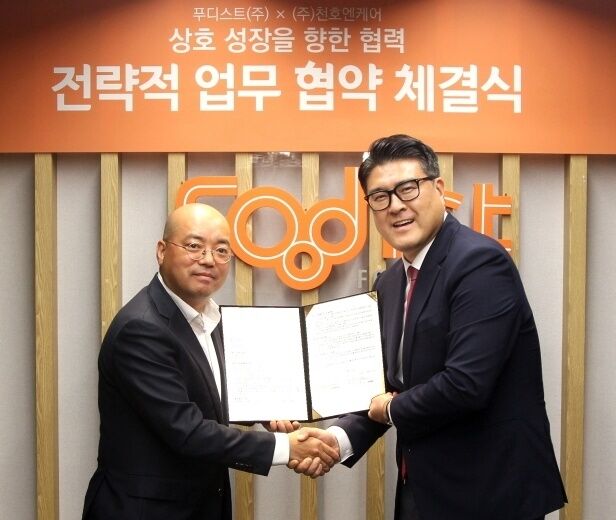 하동열 푸디스트 상품본부장(왼쪽)과 손동일 천호엔케어 대표이사가 케어푸드 브랜드 공동개발 협약식에서 기념촬영을 하고 있다. /푸디스트