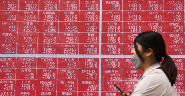 도쿄의 한 증권회사 전광판 앞에서 한 시민이 지나가고 있다. /뉴시스