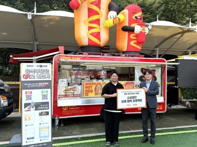 ‘푸드트럭 페스티벌’ 현장에서 진행된 푸디스트X에스에프씨 업무협약식에서 유태원 푸디스트 외식식재BU장(오른쪽)과 이덕우 에스에프씨 대표이사가 기념 사진을 찍고 있다. /푸디스트