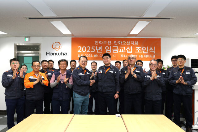 김희철 한화오션 대표이사(앞줄 왼쪽에서 네 번째)와 김유철 전국금속노조 경남지부 한화오션지회 지회장(앞줄 왼쪽에서 다섯 번째) 등 노사 교섭위원들이 임금 교섭 조인식을 마친 후 기념촬영을 하고 있다. /한화오션