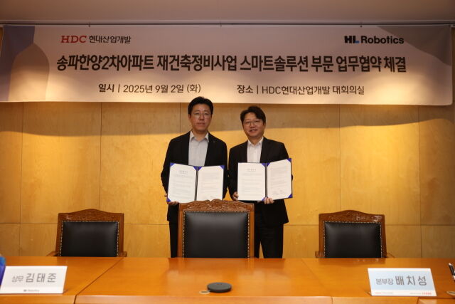 배치성 현대산업개발 본부장(오른쪽)과 김태준 HL로보틱스 상무가 업무협약을 체결한뒤 기념촬영을 하고 있다./현대산업개발