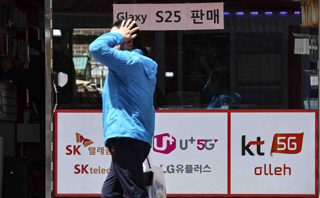 서울 시내의 한 휴대전화 대리점 앞으로 시민이 지나가고 있다. /뉴시스