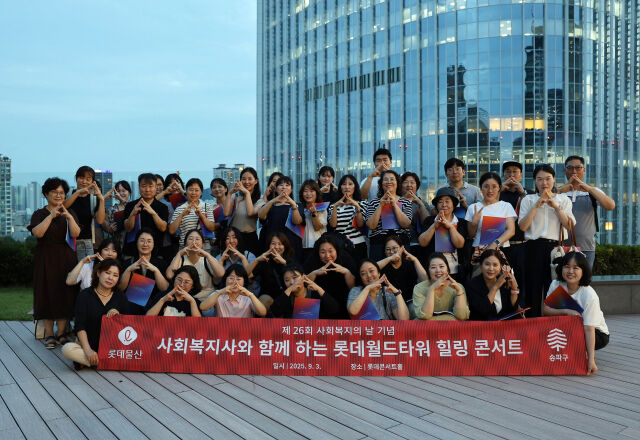 지난 3일 롯데월드 타워 힐링 콘서트에 참가한 사회복자사들이 ‘롯데월드타워 123층’을 수어로 표현하며 기념사진을 찍고 있다./롯데물산