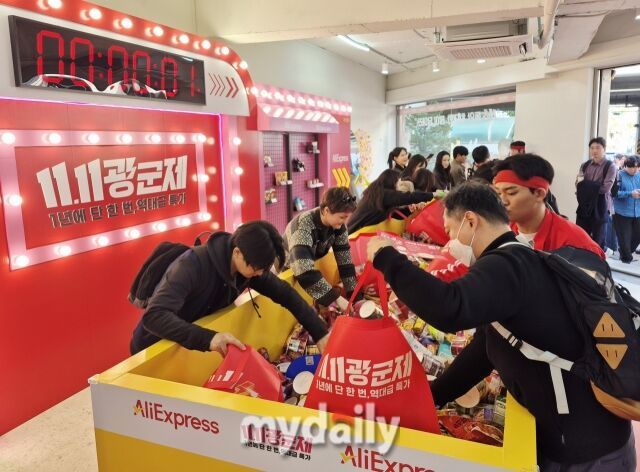 참가자들이 11초 안에 물건을 담기 위해 빠르게 손을 움직이고 있다. /방금숙 기자