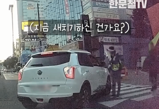 신세계백화점 천안아산점 주차장 입구에서 주차관리요원이 무리하게 끼어드는 차량을 제지하고 있다. /유튜브 한문철TV