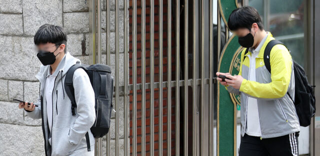 서울 시내 한 중학교 앞에서 학생들이 스마트폰을 보면서 하교하고 있다. /뉴시스