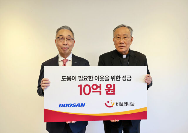 박지원 두산그룹 부회장(왼쪽)과 구요비 재단법인 바보의 나눔 이사장이 3일 서울 명동성당에서 열린 성금 전달식에서 기념촬영을 하고 있다. /두산그룹