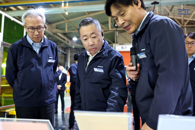 박정원 두산그룹 회장(가운데)이 12일, 충북 증평 ㈜두산 전자BG 사업장을 방문해 CCL(동박적층판) 제품 라인업을 살펴보고 있다. /두산그룹