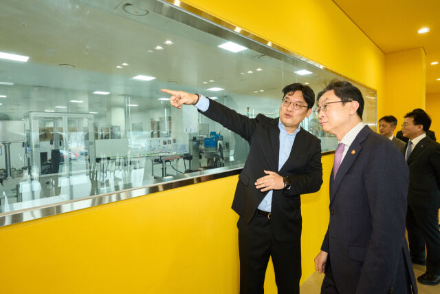 대웅제약 이승하 본부장(왼쪽)이 이억원 금융위원장에게 오송 스마트 공장의 생산 공정을 설명하고 있다. /대웅제약