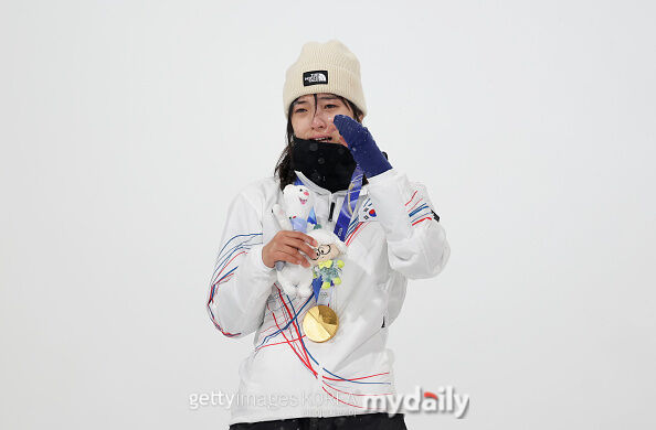 이번 동계 올림픽 한국 선수단 최초 금메달을 목에 건 최가온이 눈물을 훔치고 있다. / 게티이미지코리아