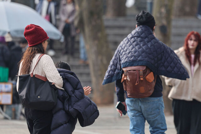 서울 용산구 남산공원에서 외국인 관광객이 두꺼운 외투를 손에 걸치고 있다. /뉴시스