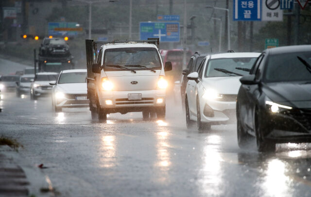 도로에서 전조등을 밝힌 자동차들이 지나가고 있다. /뉴시스