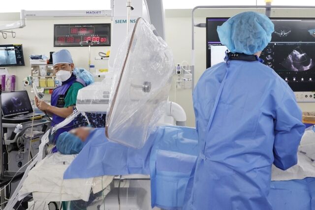 송종민 서울아산병원 심장내과 교수(왼쪽)가 심방중격결손 경피적 폐쇄술 중 심장초음파로 결손 부위를 정밀하게 확인하며 함께 시술을 시행하고 있다. /서울아산병원