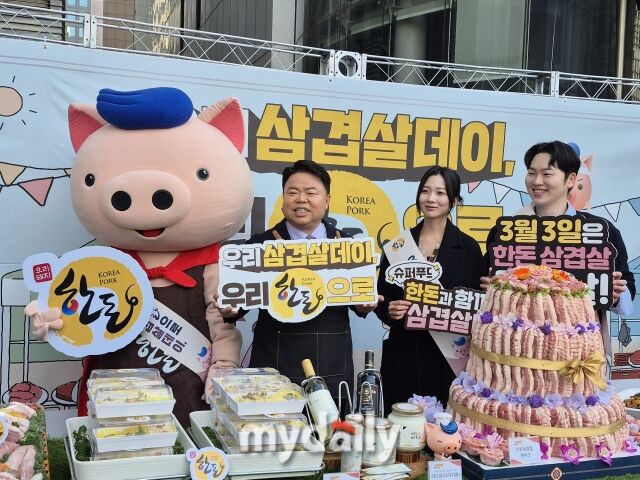 이기홍 한돈자조금관리위원회 위원장(왼쪽 두 번째)이 27일 서울 광화문 한돈 특판 행사장에서 ‘한돈 케이크’를 배경으로 모델들과 기념촬영을 하고 있다. /방금숙 기자