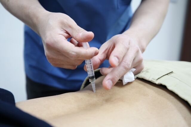 자생한방병원 의료진이 허리 통증을 호소하는 환자에게 약침 치료를 실시하고 있다. /자생한방병원