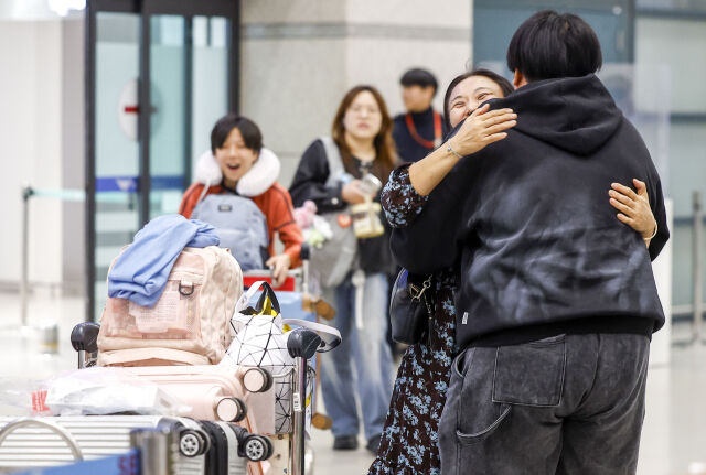 중동 상황 악화로 정부가 전세기를 투입한 가운데 9일 새벽 아부다비를 출발한 정부 전세기 탑승객들이 인천국제공항 1터미널을 통해 귀국하며 가족을 만나고 있다. /뉴시스