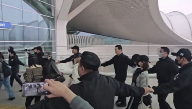 하츠투하츠가 공항에서 '강강술래식' 경호를 받으며 출국했다. / 온라인 커뮤니티