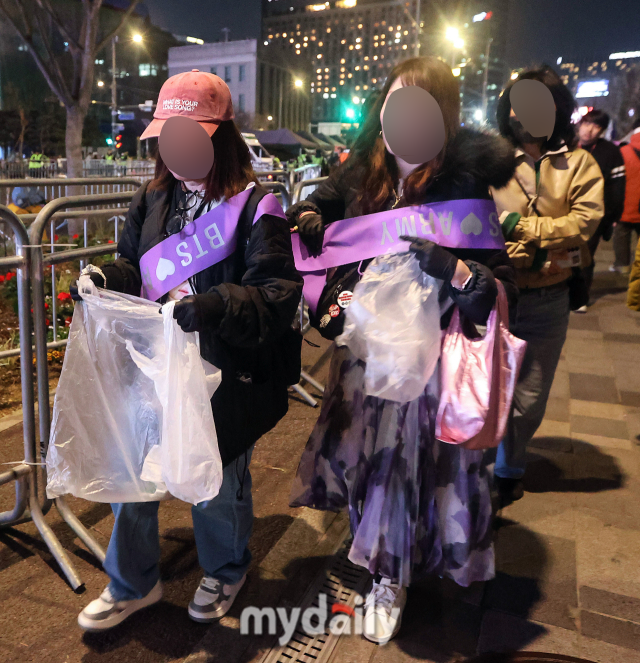 2026년 3월 21일 오후 서울 광화문 광장에서 방탄소년단 'BTS 컴백 라이브: ARIRANG' 공연이 열렸다. BTS 아미가 공연 후 쓰레기를 정리하고 있다. / 한국온라인사진기자협회 공동취재단
