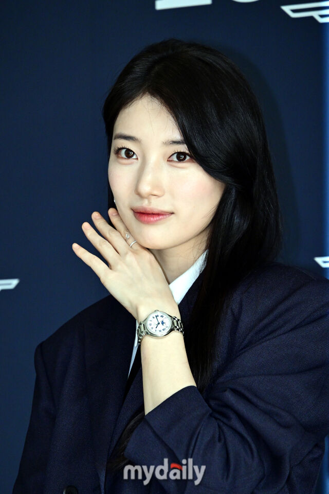  수지가 꽃받침 포즈를 취하며 취재진을 바라보고 있다.