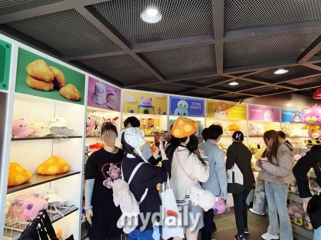 굿즈숍 ‘메이플스토어’에서 방문객들이 게임 속 아이템을 형상화한 기념품을 살펴보고 있다. 주황버섯 인형 모자와 에오스타워 드링크 보틀 등은 이곳에서만 만나볼 수 있다. /방금숙 기자