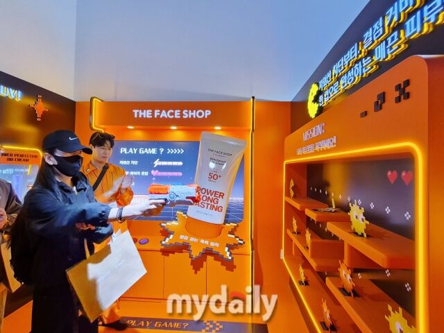 1층 브랜드 부스에서 방문객이 총 쏘기 이벤트 프로그램에 참여하고 있다. /방금숙 기자