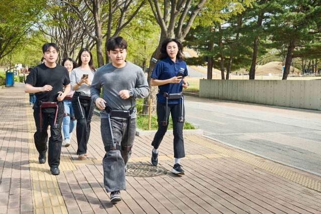 러너들이 보행 보조 로봇을 착용하고 체험하고 있다. 해당 로봇의 슬로 조깅 모드는 일정한 보행 리듬을 유지해 운동 효과를 높이도록 설계됐다. /위로보틱스