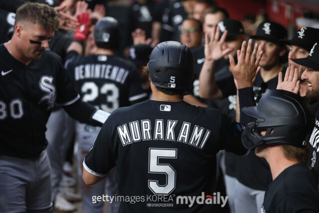 무라카미(가운데 5번)가 홈런을 날란 뒤 더그아웃에서 동료들의 축하를 받고 있다. /게티이미지코리아