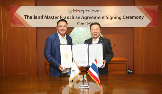윤홍근 제너시스BBQ 그룹 회장(오른쪽)과 현지 파트너사 대표 모습. /제너시스BBQ
