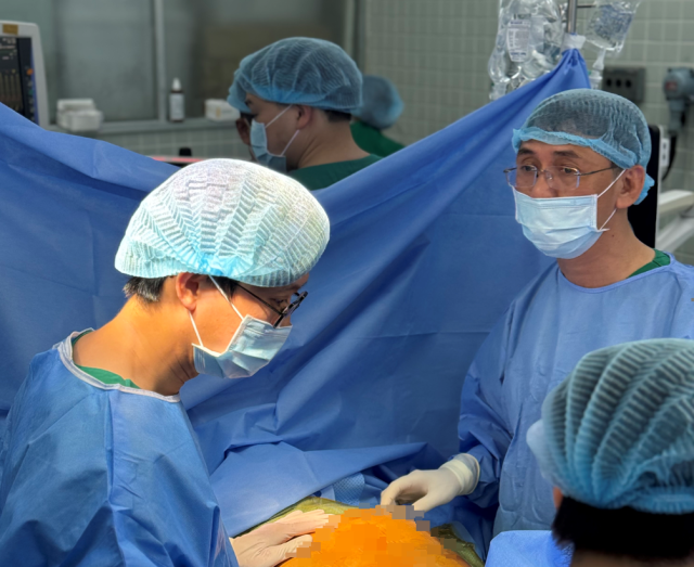 양영호 교수(왼쪽)와 응우옌 호앙 빈 씨가 수술을 하고 있다. /세브란스병원