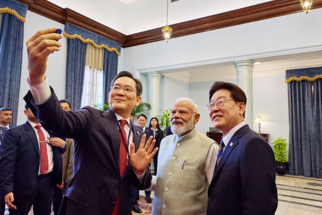 이재용 회장(왼쪽)이 20일 인도를 국빈 방문 중인 이재명 대통령과 뉴델리 영빈관 하이데라바드 하우스에서 열린 나렌드라 모디 총리 주최 오찬 및 한-인도 경제인 대화에서 모디 총리와 함께 인도 노이다 공장에서 생산한 갤럭시Z플립7으로 셀카를 찍고 있는 모습. /뉴시스