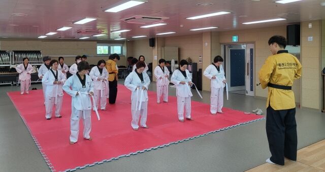 참가자들이 수업에 앞서 태권도복 띠 매기를 하고 있다. /태권도진흥재단 제공