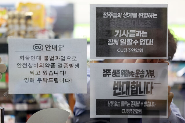 27일 서울 시내의 한 CU 편의점에서 CU가맹점주연합회 회원 점주가 항의 피켓을 붙이고 있다. /뉴시스