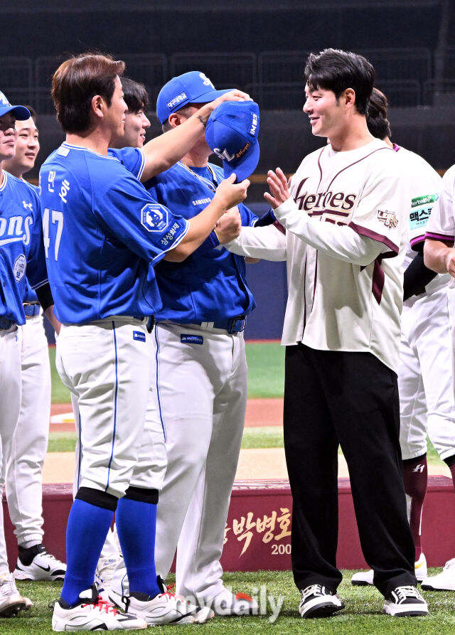 강민호가 기념촬영을 하기 전 자신의 삼성 모자를 박병호에게 건네고 있다.