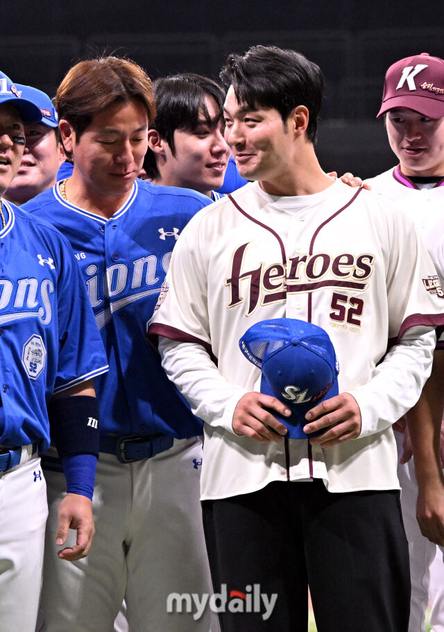 강민호가 박병호가 들고 있는 모자의 위치를 바라보고 있다.