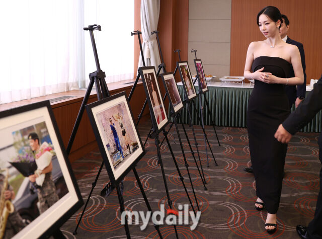 ▲ 한 해 연예, 스포츠 현장을 담은 사진기자들의 사진을 관람하고 있다.