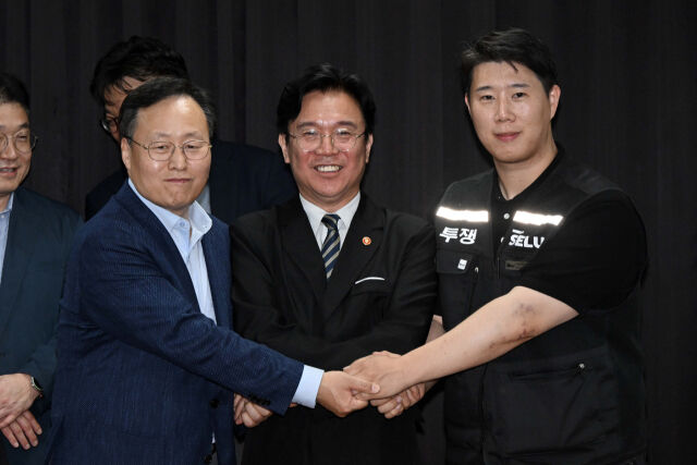 삼성전자 노사 협상이 잠정 합의된 지난 20일 경기도 수원시 장안구 경기지방고용노동청에서 (왼쪽부터) 여명구 DS(디바이스솔루션·반도체 사업 담당) 피플팀장, 김영훈 고용노동부 장관, 최승호 삼성전자 노조 공동투쟁본부 위원장이 손을 맞잡고 있다. /뉴시스