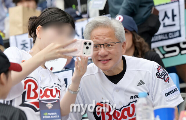 엔비디아 CEO 젠슨황이 7일 오후 서울 잠실야구장에서 진행된 '2026 프로야구 KBO리그' 두산베어스와 키움히어로즈의 경기에서 시구를 마친 뒤 야구팬과 셀카를 찍고 있다./송일섭 기자