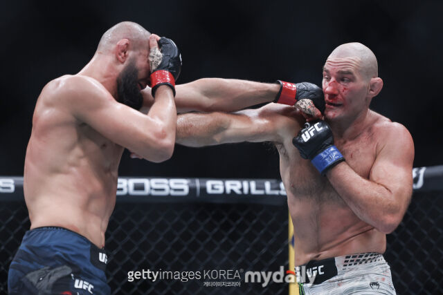 치마예프(왼쪽)가 5월 10일 벌어진 UFC 328에서 스트릭랜드에게 펀치를 허용하고 있다. /게티이미지코리아