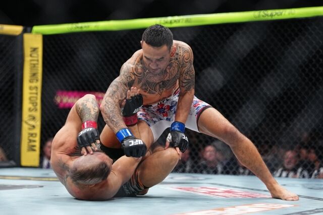 할로웨이(위)가 12일 맥그리거와 경기에서 파운딩을 퍼붓고 있다. /UFC 제공