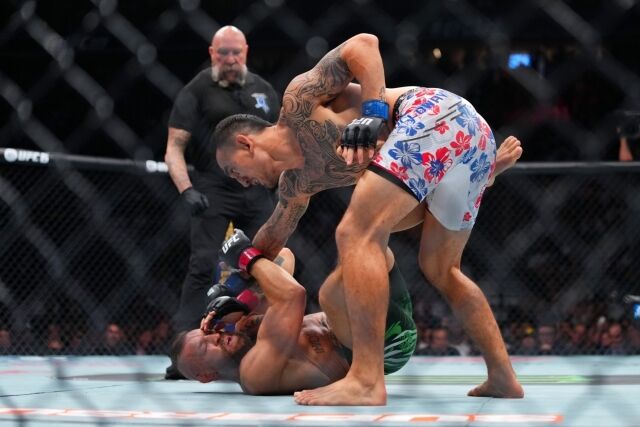 맥그리거(아래)가 하위포지션에서 할로웨이에게 파운딩을 내주고 있다. /UFC 제공