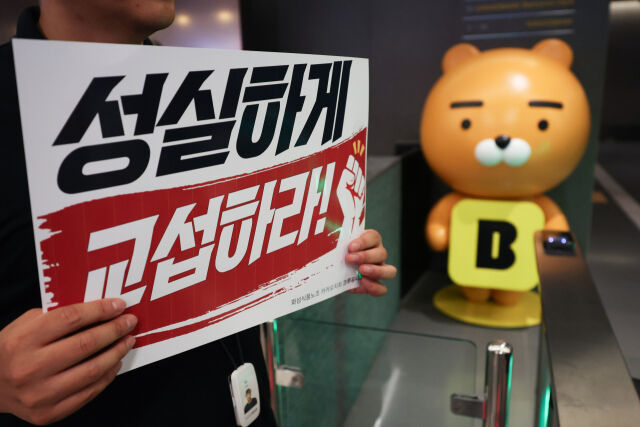 민주노총 화섬식품노조 카카오지회 조합원들이 21일 카카오뱅크가 입주한 경기 성남시 판교테크원에서 사측의 임금 인상률과 성과급 등 보상 체계를 규탄하는 피켓 시위를 하고 있다. /뉴시스